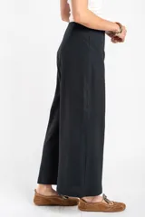Pantalón negro de corte ancho y relajado, confeccionado en algodón texturizado.