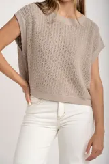 Chaleco sin mangas de tejido de punto color rosado pálido, con textura calada y acabado lurex, corte al cuerpo y cuello redondo.