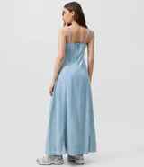 Vestido largo de jean celeste con escote corazón, breteles finos y recortes estructurados en el busto.