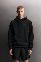 Sudadera de hombre Zara Athleticz de ajuste relajado (relaxed fit), color marrón, confeccionada en tejido técnico compacto con mezcla de algodón y elasticidad. Cuenta con cuello con capucha ajustable con cordones negros, manga larga, bolsillo frontal tipo canguro con un pequeño bolsillo termofijado con cierre, y acabados con rib en puños y cintura.