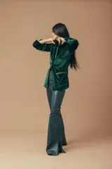 Blazer de terciopelo verde con solapas con detalles en cuero marrón y botón de guampa.