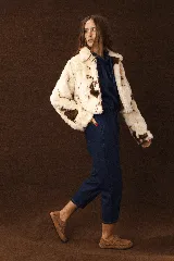 Zapato tipo zueco de cuero color beige, con diseño tejido artesanal en todo el contorno y ajuste mediante correa con hebilla metálica en el empeine.