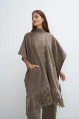 Ruana marrón con flecos y bolsillos. Terminaciones envivadas.