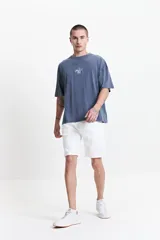 Bermuda de jean de corte regular, color blanco, con dobladillo en el ruedo, cierre frontal con botón y bolsillos laterales y traseros.