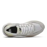 Championes New Balance modelo W5740WR1, color beige claro con detalles en blanco, amarillo pálido y negro. Confeccionados en gamuza y malla, con el logo "N" característico en los laterales.