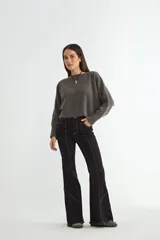 Sweater de punto negro, de corte holgado y diseño cropped, con cuello redondo y mangas largas.