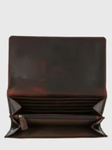 Billetera cruzada de cuero natural con solapa imantada, compartimento principal, bolsillo divisor con cierre, ranuras para tarjetas y correa ajustable y removible.