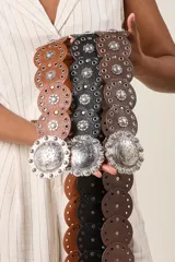 Cinturón ancho de ecocuero color marrón con apliques metálicos plateados y hebilla grabada estilo western.