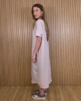 Vestido midi estilo túnica color celeste con rayas verticales blancas, cuello camisero, mangas cortas y cierre frontal con botones ocultos.