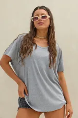 Remera oversize gris de tejido morley, con escote en V y mangas cortas holgadas.