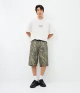 Bermuda baggy de sarga para hombre, con estampado camuflado en tonos verde militar, color principal Verde Militar. Cuenta con cintura con trabilla, cierre tradicional y bolsillos delanteros y traseros.