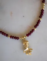 Collar de cuentas de jade facetadas color bordó y cuentas doradas, con un dije de pez dorado.