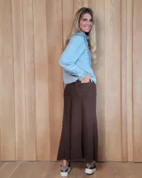 Pollera larga de corte recto en denim color arena, con diseño de cinco bolsillos, cierre frontal con botón y costuras a la vista.