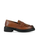 Mocasines de cuero color marrón tostado, con detalle de flecos y empeine estructurado. Poseen suela gruesa y tacón bajo en color negro.