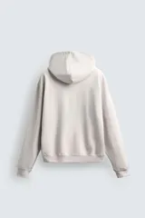 Sudadera tipo hoodie de color blanco hueso, con capucha, manga larga y bolsillo canguro frontal. Presenta un calce relajado y tejido de algodón con interior afelpado.