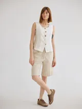 Short de lino color rojo, de tiro medio, con cierre frontal y bolsillos laterales. Presenta un diseño clásico y versátil.