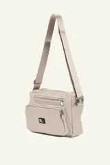 Bandolera color beige con correa larga regulable. Cuenta con múltiples bolsillos con cierre y logo de la marca en etiqueta negra.