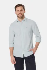 Camisa de manga larga, corte slim fit, color celeste con finas rayas verticales blancas. Presenta cuello camisero y un pequeño logo bordado en el pecho.
