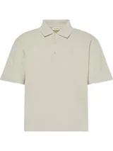 Chomba Calvin Klein de corte relajado, confeccionada en tejido de punto acanalado color beige. Presenta cuello clásico, cartera con tres botones y logo de la marca bordado sutilmente en el pecho.