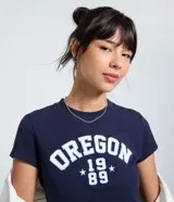 Remera de algodón color azul marino con cuello redondo y estampado frontal con la inscripción 'Oregon 1989' en tonos blanco y celeste.