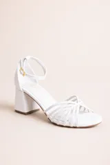 Sandalia de taco cuadrado bajo color blanco, con múltiples tiras finas cruzadas en el empeine y tira ajustable en el tobillo con hebilla dorada.