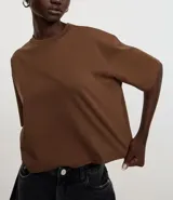 Remera cropped de manga corta, cuello redondo y calce oversized, confeccionada en tejido de algodón tipo media malla.