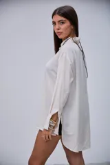 Camisa de manga larga color beige, con cuello clásico y botones frontales.