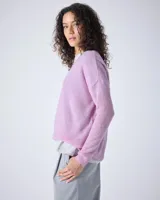 Sweater de punto fino color gris claro, con cuello en V y mangas largas. El tejido parece ser ligeramente transparente o muy liviano.