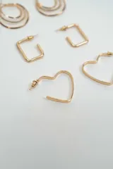 Set de tres pares de aros dorados con diferentes diseños: aros tipo argolla triple, aros rectangulares y aros con forma de corazón.
