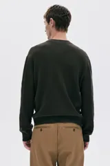 Buzo de punto acanalado color verde oscuro, de manga larga y cuello redondo, con corte regular fit.