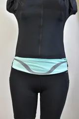 Riñonera deportiva color celeste con cierre superior y tira reflectiva gris.