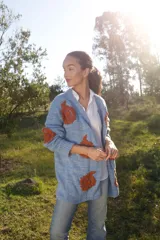 Cárdigan celeste pálido de lana merino con bordados florales color ladrillo hechos a mano.