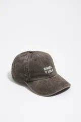 Gorro tipo gorra con visera de color marrón con efecto desgastado, con bordado frontal del logo de la marca en color verde claro.
