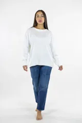 Buzo de punto color blanco, con cuello redondo, mangas largas y puños acanalados. Presenta un diseño de corte recto y holgado con terminaciones acanaladas en el ruedo.