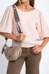 Blusa color rosa pálido, de manga larga abullonada con puño elástico y escote redondo.