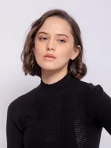 Polera negra de tejido de punto con diseño de franjas verticales y pequeños puntos calados. Presenta cuello alto y un ajuste ceñido al cuerpo.