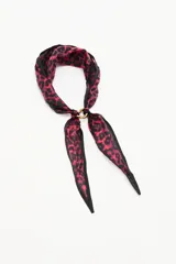 Pashmina con estampado animal print en tonos fucsia y negro, confeccionada en una mezcla de cupro y modal. Presenta un detalle de argolla metálica dorada que sujeta los extremos.