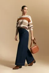 Jean de corte wide leg y tiro alto, color negro con costuras en contraste color ocre. Presenta bolsillos delanteros y traseros con detalle de pespunte, y ruedo ancho con costura decorativa.