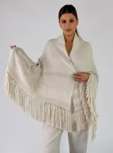 Pashmina de punto color beige con bordados sutiles y flecos largos en los bordes.