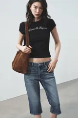 Camiseta blanca de manga corta y cuello redondo, con estampado en tipografía cursiva negra que dice "Creativity doesn't sleep" en diagonal.