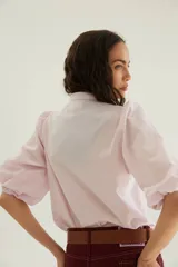 Camisa de algodón celeste con cuello mao, pechera con botones ocultos y mangas abullonadas con puños elásticos.