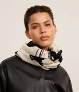 Bufanda confeccionada en franela de acrílico con flecos y estampa de follajes en blanco y negro.