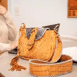 Morral de cuero vacuno color whisky con detalles en gris peltre. Tiene bolsillo trasero con cierre, cierre superior y tapa con broche. Incluye correa larga ajustable y removible. Interior forrado con bolsillo para el móvil.