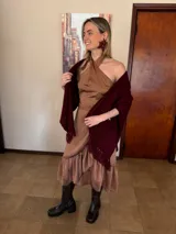 Conjunto de dos piezas color camel compuesto por un top halter cruzado y una falda cruzada con volados en el ruedo. Ambas prendas están confeccionadas en gasa liviana con caída fluida.