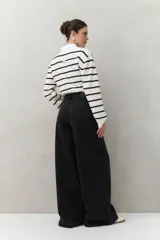 Jean de tiro alto, color negro lavado, con calce ultra wide leg y silueta amplia desde la cadera hasta el bajo.