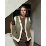 Chaleco estilo gamulán color verde militar con forro y bordes de corderito sintético blanco, diseño sin mangas.