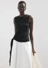 Falda midi evasé de color blanco, confeccionada en tejido de algodón con tiro medio y cintura elástica.