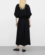 Camisa negra oversize de lino y viscosa, con cuello mao, botonadura frontal oculta por sopata, manga murciélago con vuelta bajo el codo, bolsillo en el pecho y costuras desflecadas en el canesú y las mangas.