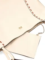 Cartera tipo shopper amplia de cuero graneado color crema, de moldería clásica y formato rectangular. Presenta pespuntes decorativos a contratono en los laterales y asas al hombro con correas de cuero. Incluye detalle de logo metálico frontal.