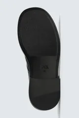 Zapato de vestir de cuero negro, estilo derby, con horma cuadrada y suela con volumen.